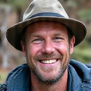 Portrait of a laughing male guide, Mark, with a nature backdrop.