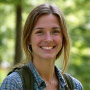 Portrait of a friendly female guide, Sarah, in a forest setting.