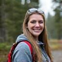 Sarah J., smiling warmly, equipped for hiking